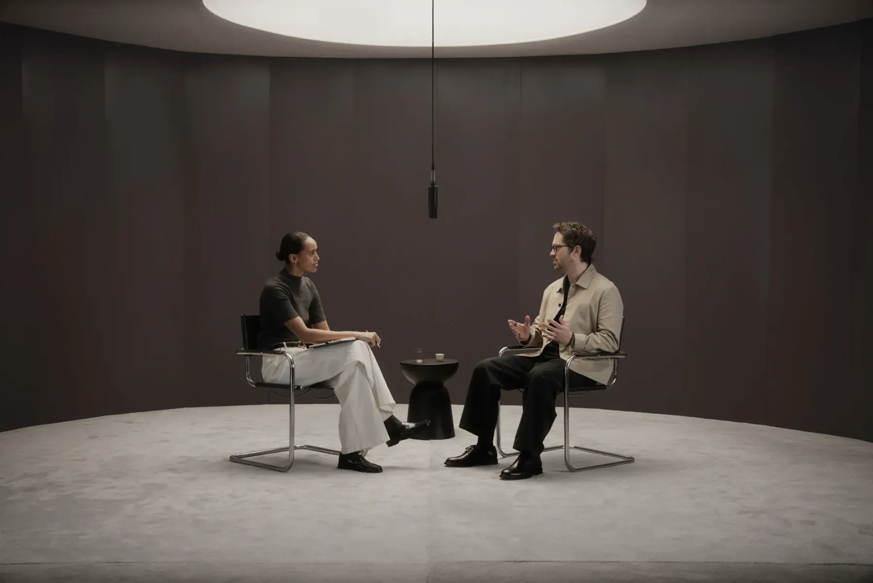 Deux personnes en conversation dans une pièce épurée, l'une porte des lunettes Even Realities