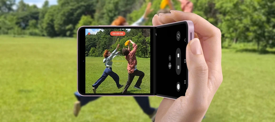 Galaxy Z Flip8 en mode FlexCam filmant deux amis qui jouent au frisbee dans un parc