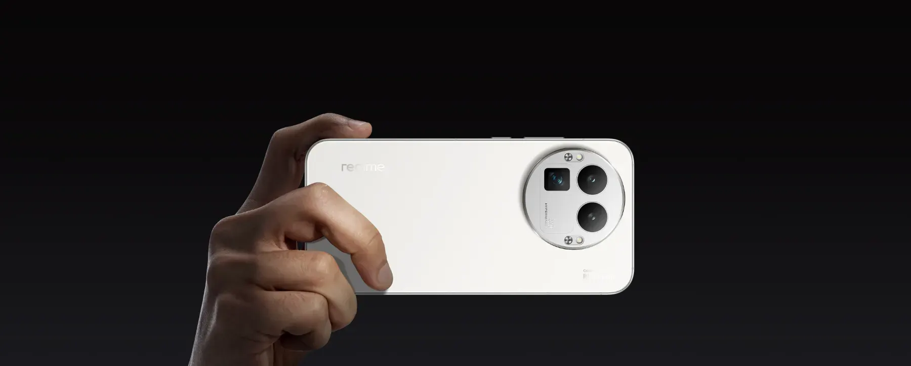 Main tenant un smartphone Realme blanc sur fond noir