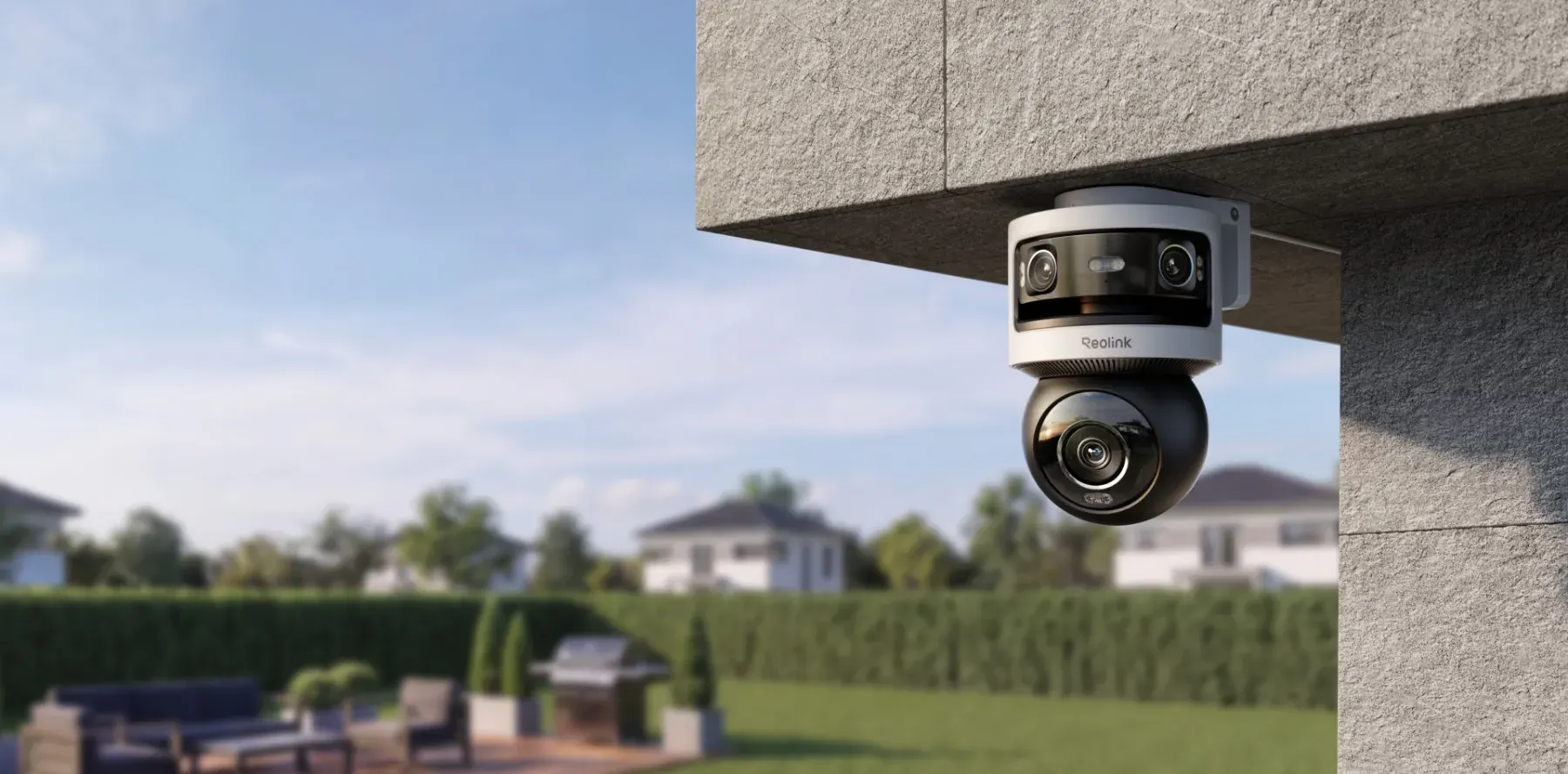 Caméra de sécurité Reolink fixée à l'angle d'une maison, face au jardin