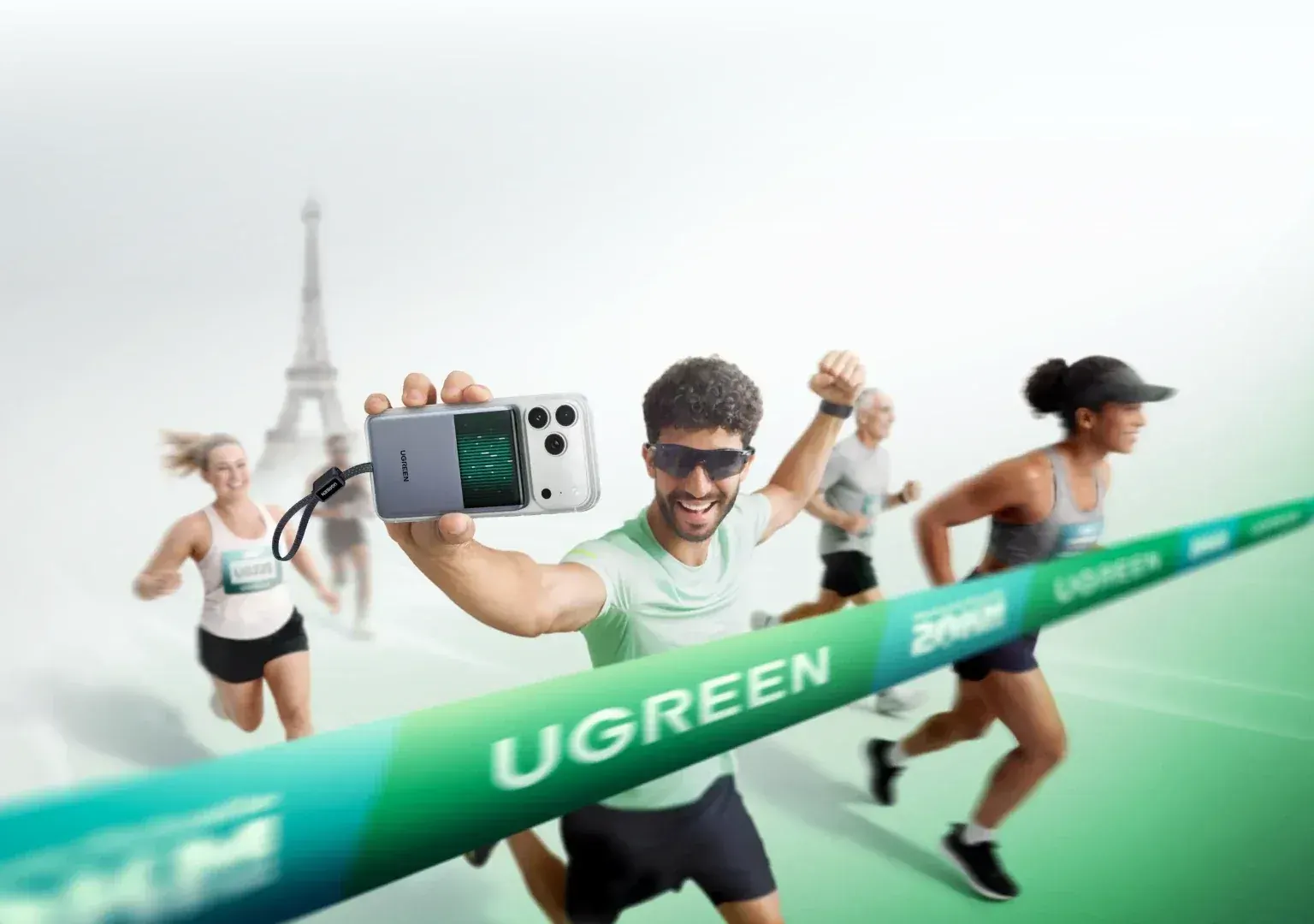 Coureurs franchissant une ligne d'arrivée, l'un tient un smartphone équipé d'une batterie Ugreen