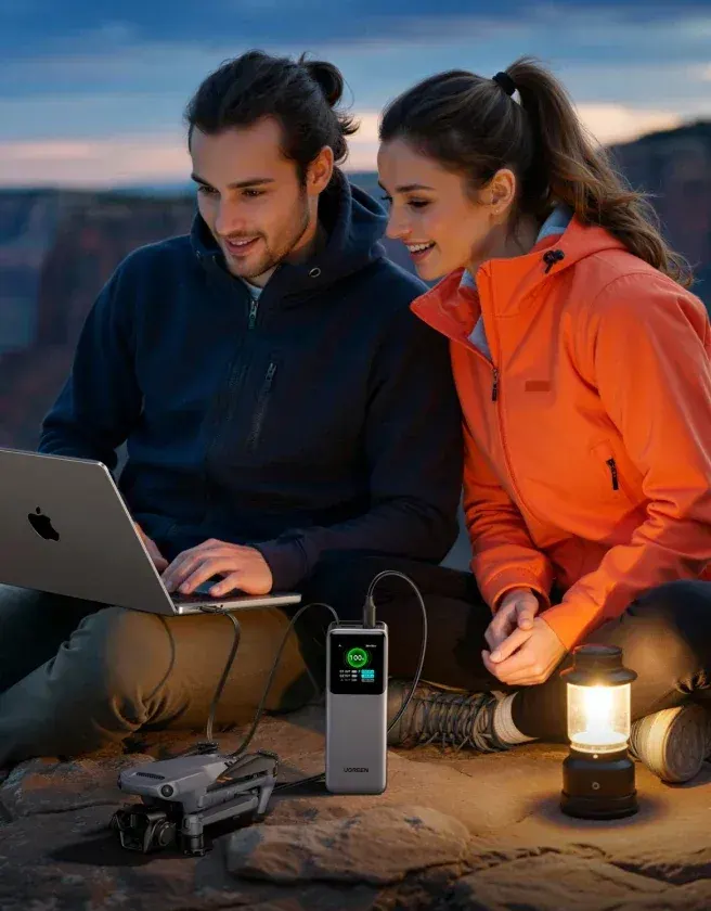 Deux randonneurs devant un ordinateur alimenté par une batterie Ugreen